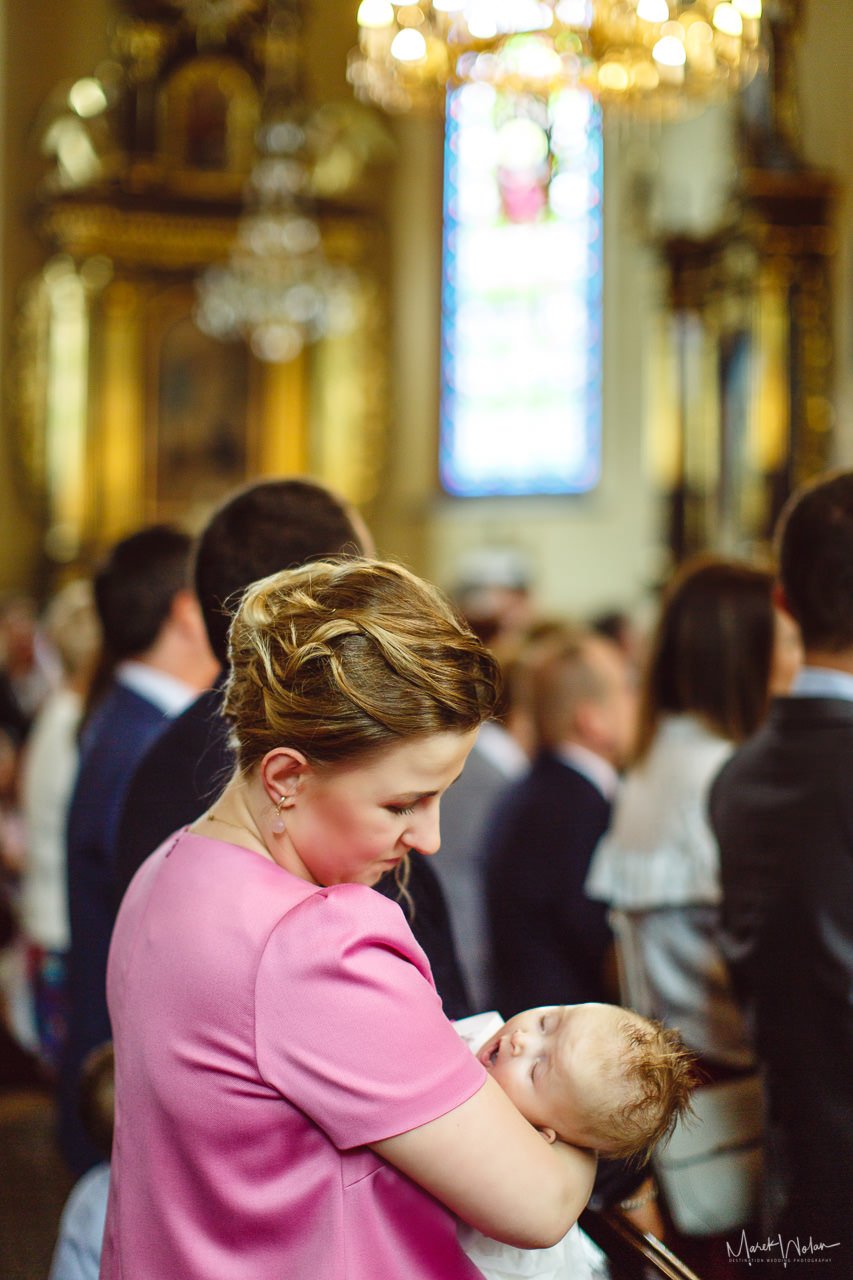 kobieta trzymająca dziecko podczas chrztu świętego